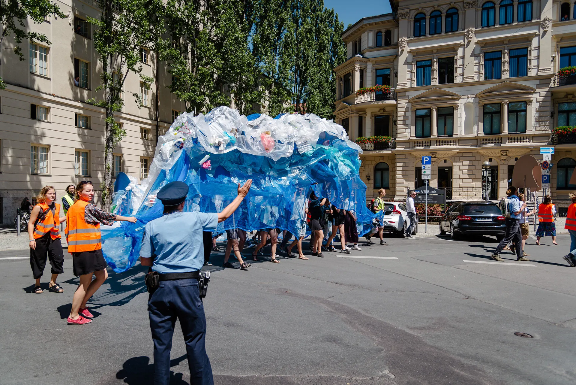 The plastic wave moves between old buildings through the city while a police officer directs traffic
