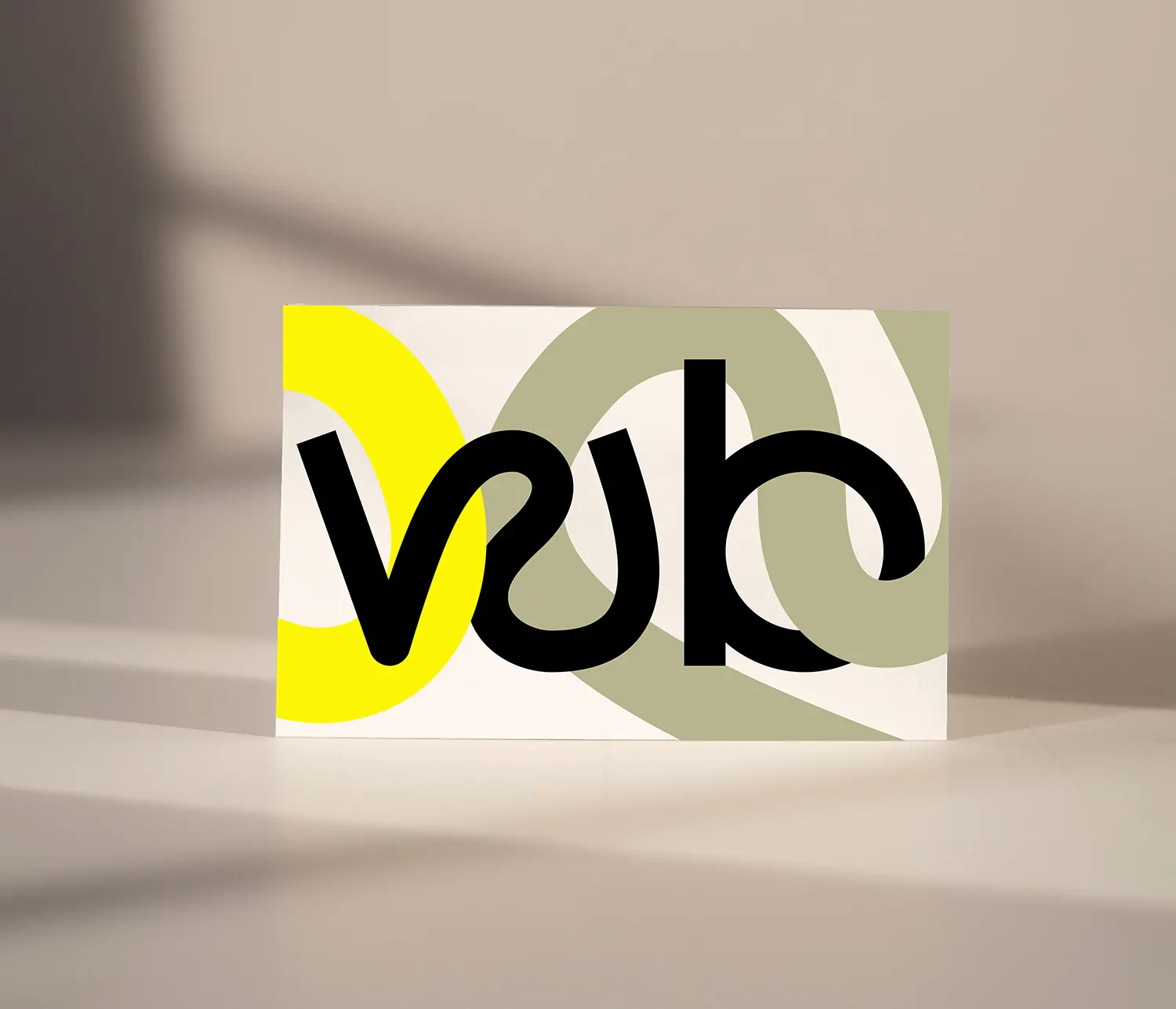 Card with the “wb” monogram in front of yellow and olive arc shapes