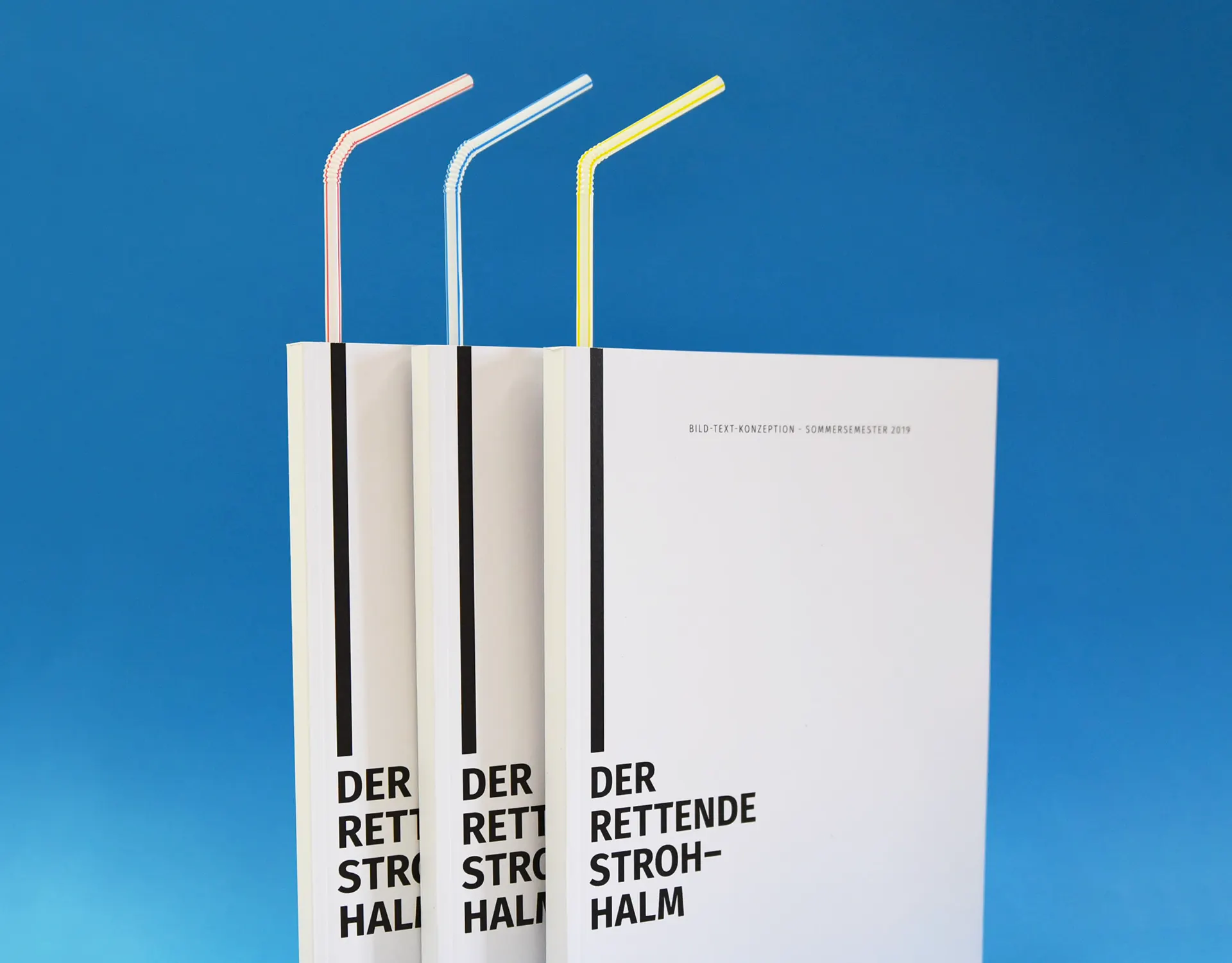 Three copies of the publication “Der rettende Strohhalm” with coloured drinking straws against a blue background